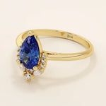 14k gold pear sapphire ring featuring white moissanite accents below the center stone. Elegant and timeless gemstone ring design. 