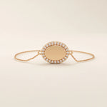 14k rose gold bracelet showcasing an oval charm encircled by pavé moissanite stones on a slim chain.
