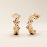 14k rose gold knot stud earrings showcasing twisted rope and polished strands interlaced with a line of round moissanites.
