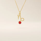 14k solid gold Capricorn symbol pendant necklace featuring a deep red garnet birthstone. A meaningful zodiac necklace perfect for personalized gifting.