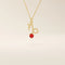14k solid gold Capricorn symbol pendant necklace featuring a deep red garnet birthstone. A meaningful zodiac necklace perfect for personalized gifting.