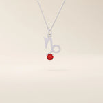 14k solid gold Capricorn symbol pendant necklace featuring a deep red garnet birthstone. A meaningful zodiac necklace perfect for personalized gifting.