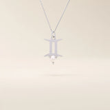 14k solid gold Gemini zodiac symbol pendant necklace with a natural pearl charm, minimalist celestial design.