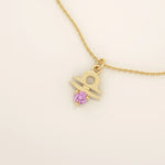 14k solid gold Libra zodiac symbol pendant necklace with a vibrant pink tourmaline. Minimalist astrology birthstone jewelry.