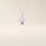 14k solid gold Libra zodiac symbol pendant necklace with a vibrant pink tourmaline. Minimalist astrology birthstone jewelry.
