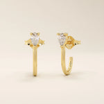 14k solid gold U-shaped stud earrings featuring a front-facing pear-cut moissanite. A unique and modern earring design. Perfect for daily wear or special occasions.