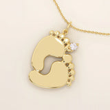 14k solid gold baby foot pendant necklace featuring a delicate tiny moissanite accent. A sentimental jewelry piece symbolizing new beginnings or motherhood. Perfect for gifting or everyday wear.