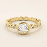 14k solid gold bezel-set solitaire engagement ring featuring a round moissanite and subtle detailing along the band. A modern twist on a classic style. Perfect for timeless proposals.