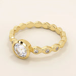 14k solid gold bezel-set solitaire engagement ring featuring a round moissanite and subtle detailing along the band. A modern twist on a classic style. Perfect for timeless proposals.