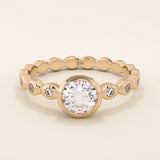 14k solid gold bezel-set solitaire engagement ring featuring a round moissanite and subtle detailing along the band. A modern twist on a classic style. Perfect for timeless proposals.