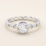 14k solid gold bezel-set solitaire engagement ring featuring a round moissanite and subtle detailing along the band. A modern twist on a classic style. Perfect for timeless proposals.
