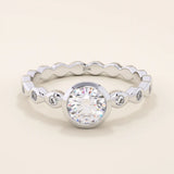 14k solid gold bezel-set solitaire engagement ring featuring a round moissanite and subtle detailing along the band. A modern twist on a classic style. Perfect for timeless proposals.