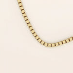 14k solid gold box chain necklace with square-shaped links and a smooth finish. A timeless and durable gold chain. Ideal for daily wear or layering.