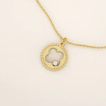 14k solid gold circle pendant necklace featuring a clover-shaped cutout and a single sparkling moissanite. Symbolic and delicate design.