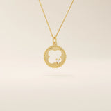 14k solid gold circle pendant necklace featuring a clover-shaped cutout and a single sparkling moissanite. Symbolic and delicate design.