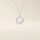 14k solid gold circle pendant necklace featuring a clover-shaped cutout and a single sparkling moissanite. Symbolic and delicate design.