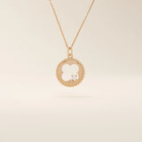 14k solid gold circle pendant necklace featuring a clover-shaped cutout and a single sparkling moissanite. Symbolic and delicate design.
