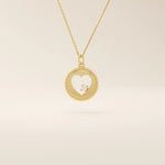 14k solid gold circle pendant necklace featuring a heart-shaped cutout and a single sparkling moissanite. Delicate and meaningful design.