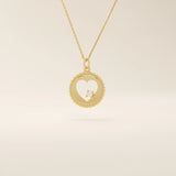 14k solid gold circle pendant necklace featuring a heart-shaped cutout and a single sparkling moissanite. Delicate and meaningful design.