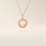 14k solid gold circle pendant necklace featuring a heart-shaped cutout and a single sparkling moissanite. Delicate and meaningful design.