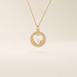 14k solid gold circle pendant necklace featuring a heart-shaped cutout and a single sparkling moissanite. Delicate and meaningful design.