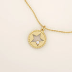 14k solid gold circle pendant necklace featuring a star-shaped cutout and a single sparkling moissanite. Delicate and celestial-inspired design.