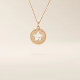 14k solid gold circle pendant necklace featuring a star-shaped cutout and a single sparkling moissanite. Delicate and celestial-inspired design.