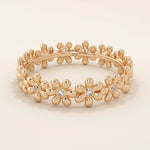 14k solid gold eternity band ring adorned with tiny daisy flower motifs. Delicate and whimsical statement jewelry for women.