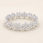 14k solid gold eternity band ring adorned with tiny daisy flower motifs. Delicate and whimsical statement jewelry for women.