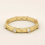 14k solid gold minimalist band ring with bezel-set moissanites around the band. Modern eternity statement jewelry for women.