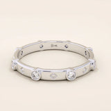 14k solid gold minimalist band ring with bezel-set moissanites around the band. Modern eternity statement jewelry for women.
