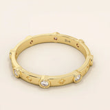 14k solid gold minimalist band ring with bezel-set moissanites around the band. Modern eternity statement jewelry for women.