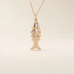 14k solid gold necklace featuring a minimalist fish design. Symbolic and playful gold jewelry. Ideal for everyday wear or gifting.