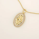 14k solid gold oval compass pendant necklace with pave moissanite stones around and a 4-point star design in the center. Elegant and symbolic gold jewelry. Perfect for daily wear.