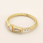14k solid gold promise ring featuring tapered baguette and triangle-cut moissanites in bezel settings. A modern geometric design with elegant sparkle.