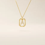 14k solid gold rectangle-shaped necklace featuring a personalized dangling initial letter. A modern and customizable everyday accessory.