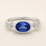 14k solid gold ring with bezel set oval sapphire and accent moissanites. A vintage-inspired solitaire gemstone ring with timeless charm.