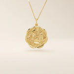 14k solid gold round pendant necklace with an embossed Sakura flower design. Delicate and nature-inspired gold jewelry. Ideal for daily minimalist style.