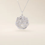14k solid gold round pendant necklace with an embossed Sakura flower design. Delicate and nature-inspired gold jewelry. Ideal for daily minimalist style.