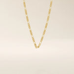 14k solid gold slim Figaro chain necklace with alternating short and long links. A classic and lightweight gold chain. Perfect for layering or daily wear.
