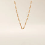 14k solid gold slim Figaro chain necklace with alternating short and long links. A classic and lightweight gold chain. Perfect for layering or daily wear.