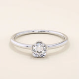 14k solid gold solitaire engagement or promise ring featuring a delicate small flower design. Minimalist and feminine everyday jewelry.
