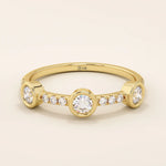 14k solid gold stacking ring featuring a half-eternity design with three bezel-set moissanites. Minimalist and versatile style.