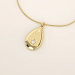 14k solid gold teardrop pendant necklace featuring a single tiny moissanite in the center. Minimalist and timeless jewelry design. Perfect for everyday wear.