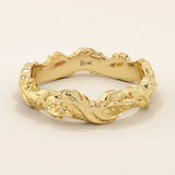 Elegant 14k solid yellow gold wedding band featuring bold, raised ivy leaf motifs wrapping seamlessly around the band. The intricate nature-inspired design showcases polished contours and subtle curves, adding depth and dimension. Perfect as a statement piece or unique nature-themed wedding ring.
