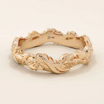 Romantic 14k solid rose gold wedding band adorned with sculpted ivy leaf motifs flowing around the entire band. The warm blush tones of the gold enhance the nature-inspired design, making it an ideal choice for those seeking a unique and meaningful botanical wedding ring.
