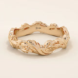 Romantic 14k solid rose gold wedding band adorned with sculpted ivy leaf motifs flowing around the entire band. The warm blush tones of the gold enhance the nature-inspired design, making it an ideal choice for those seeking a unique and meaningful botanical wedding ring.
