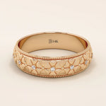 14k solid gold wedding band with embossed flower patterns wrapping around the band. A romantic and textured gold ring. Perfect for daily wear or as a unique wedding band.