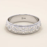 14k solid gold wedding band with embossed flower patterns wrapping around the band. A romantic and textured gold ring. Perfect for daily wear or as a unique wedding band.