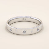 14k solid white gold wedding band featuring dainty celestial star engravings with shimmering moissanites set in their centers, offering a sleek and modern stacking ring style.
